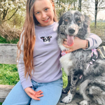 child smiling while wearing a custom embroidered hoodie featuring a hand-drawn pet portrait, the perfect personalised pet gift