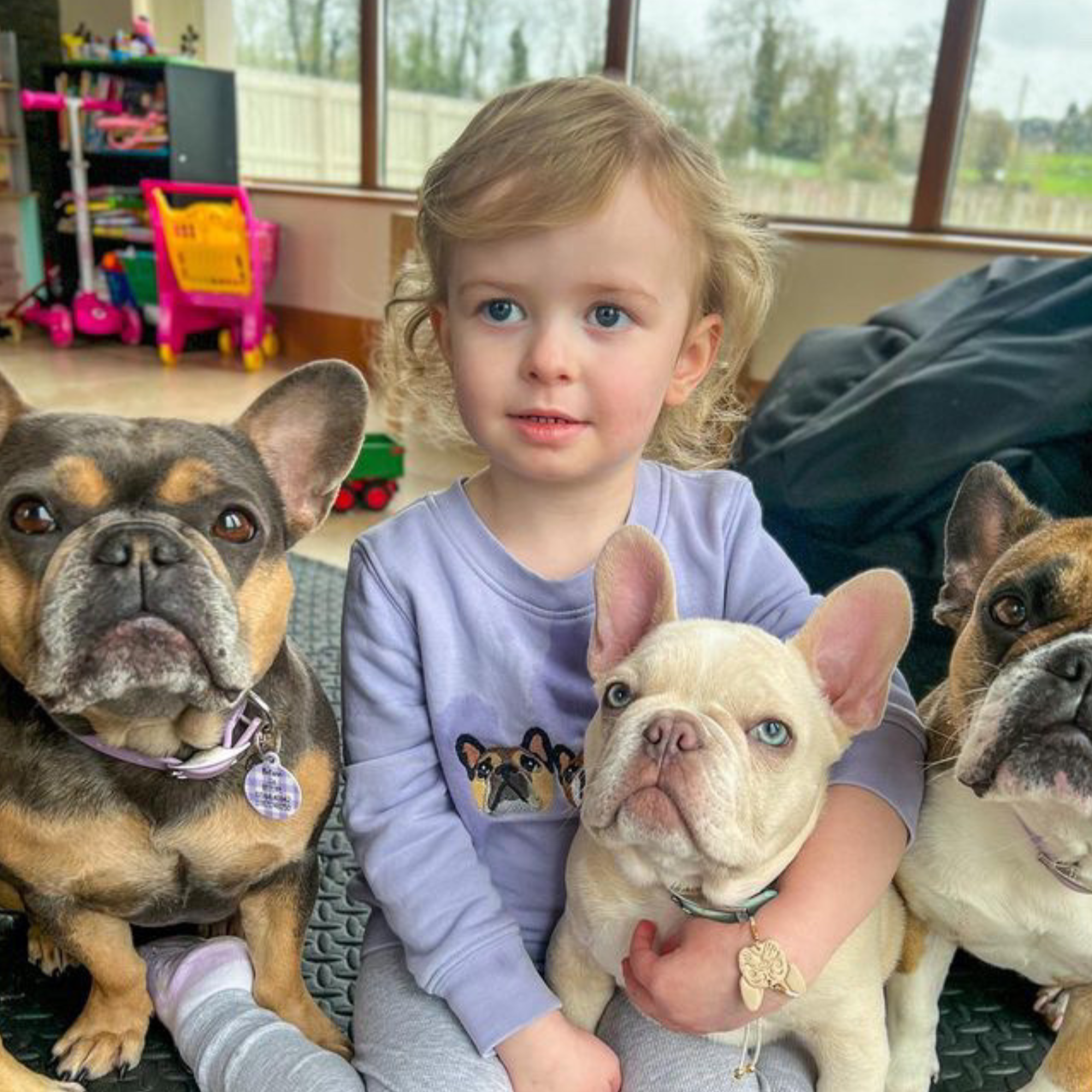 child smiling while wearing a custom embroidered sweatshirt with a hand-drawn pet portrait on organic cotton fabric.