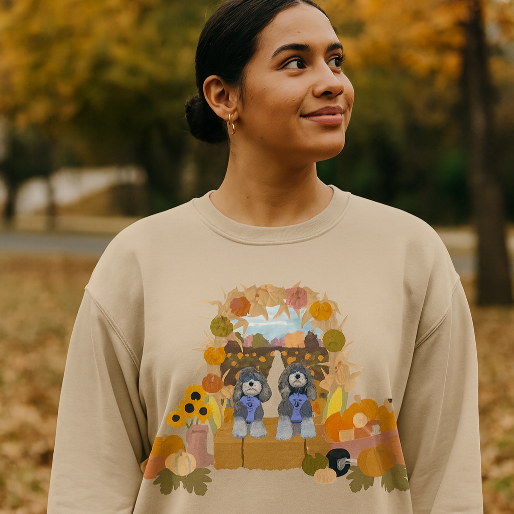 Woman wearing a beige sweatshirt with a graphic design outdoors in autumn.
