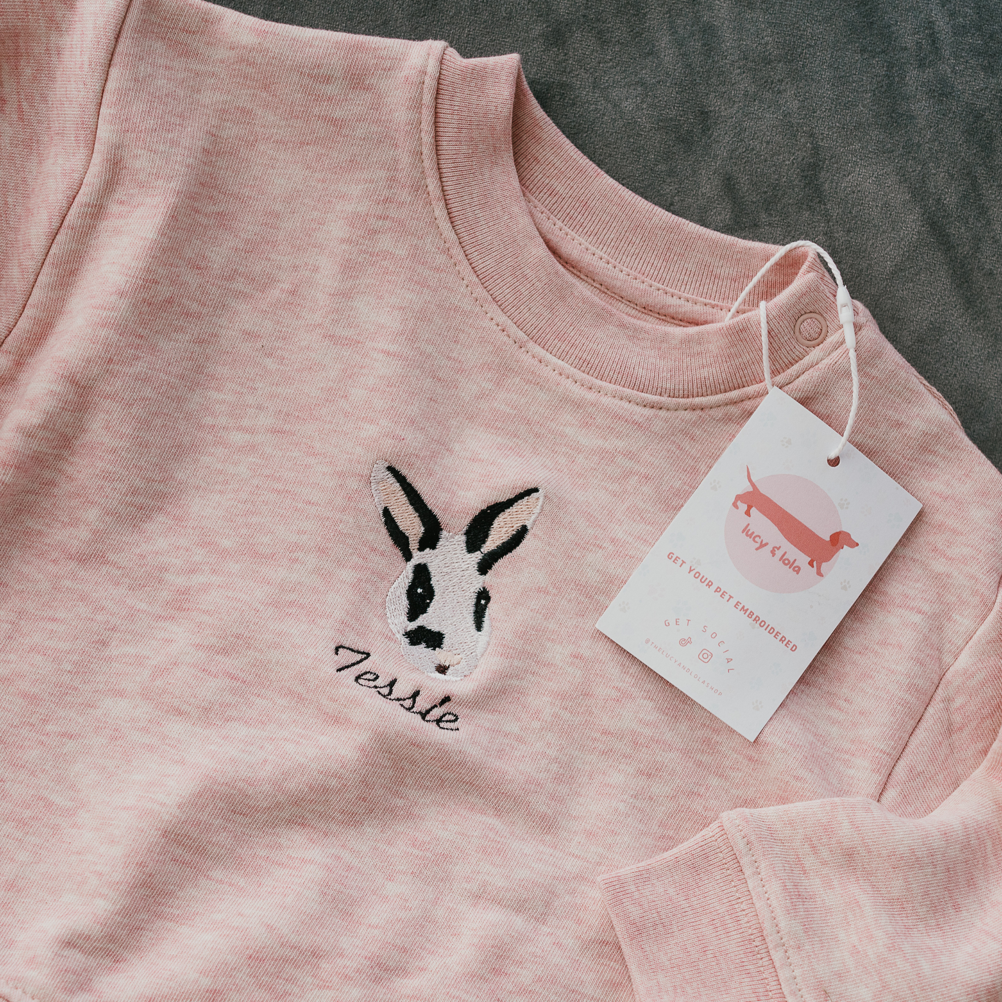 Custom embroidered sweatshirt featuring a hand-drawn pet portrait on organic cotton fabric.