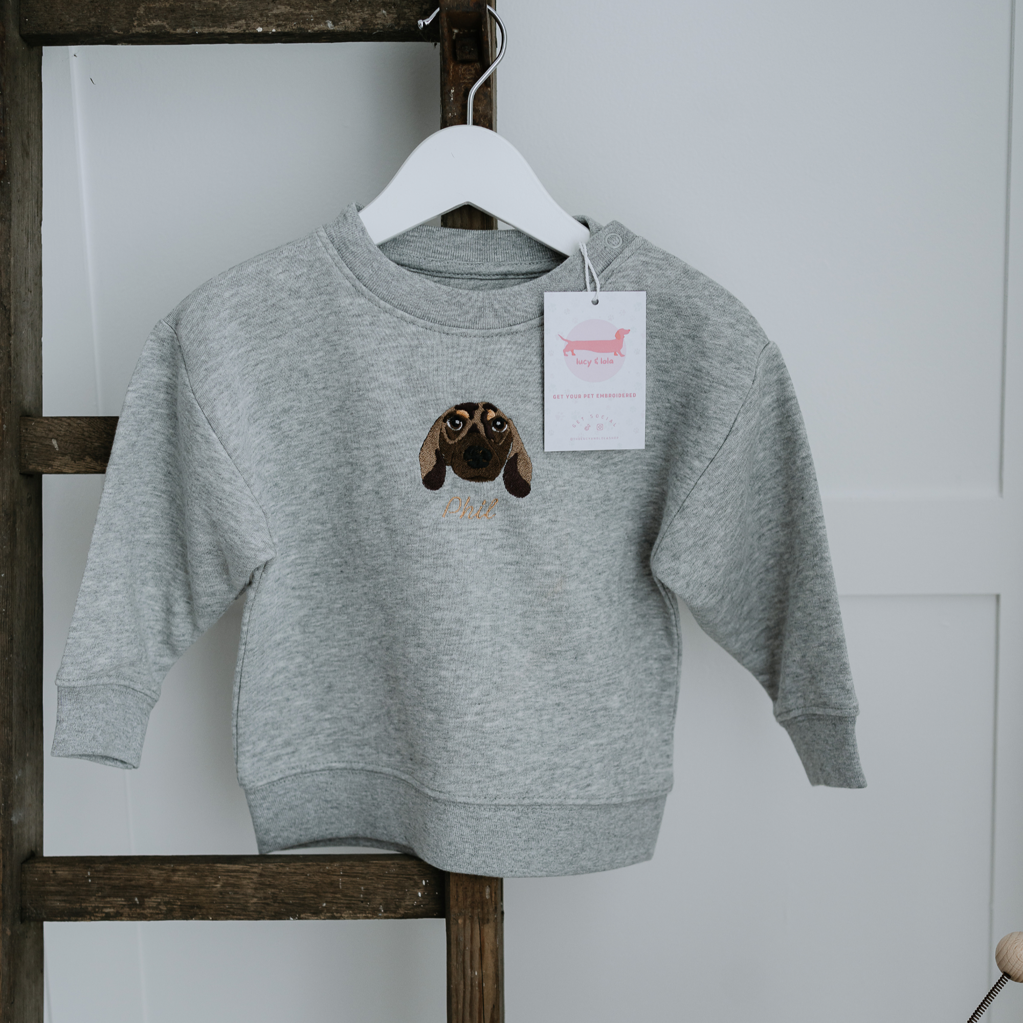 Custom embroidered sweatshirt featuring a hand-drawn pet portrait on organic cotton fabric.
