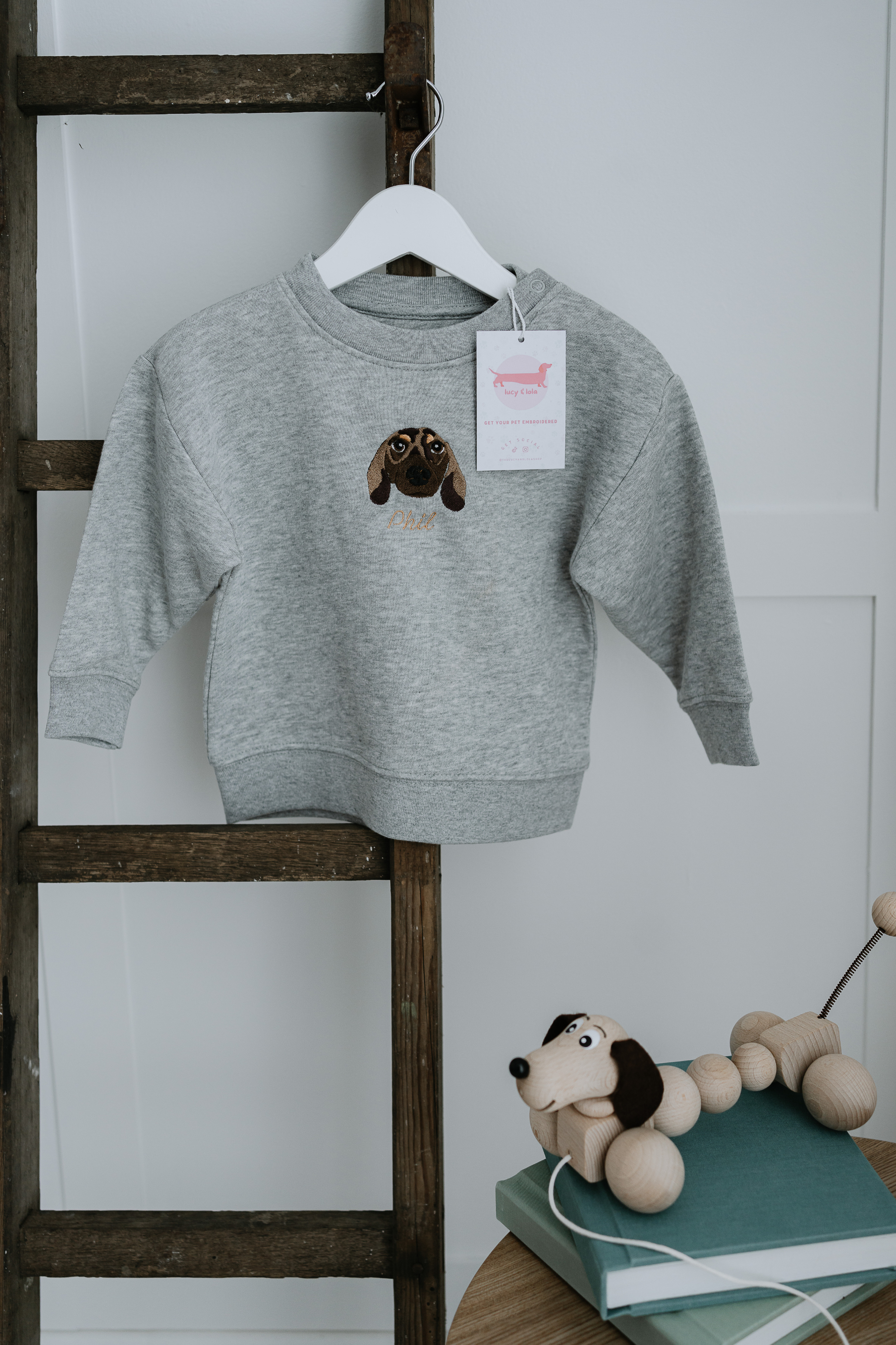 Custom embroidered sweatshirt featuring a hand-drawn pet portrait on organic cotton fabric.