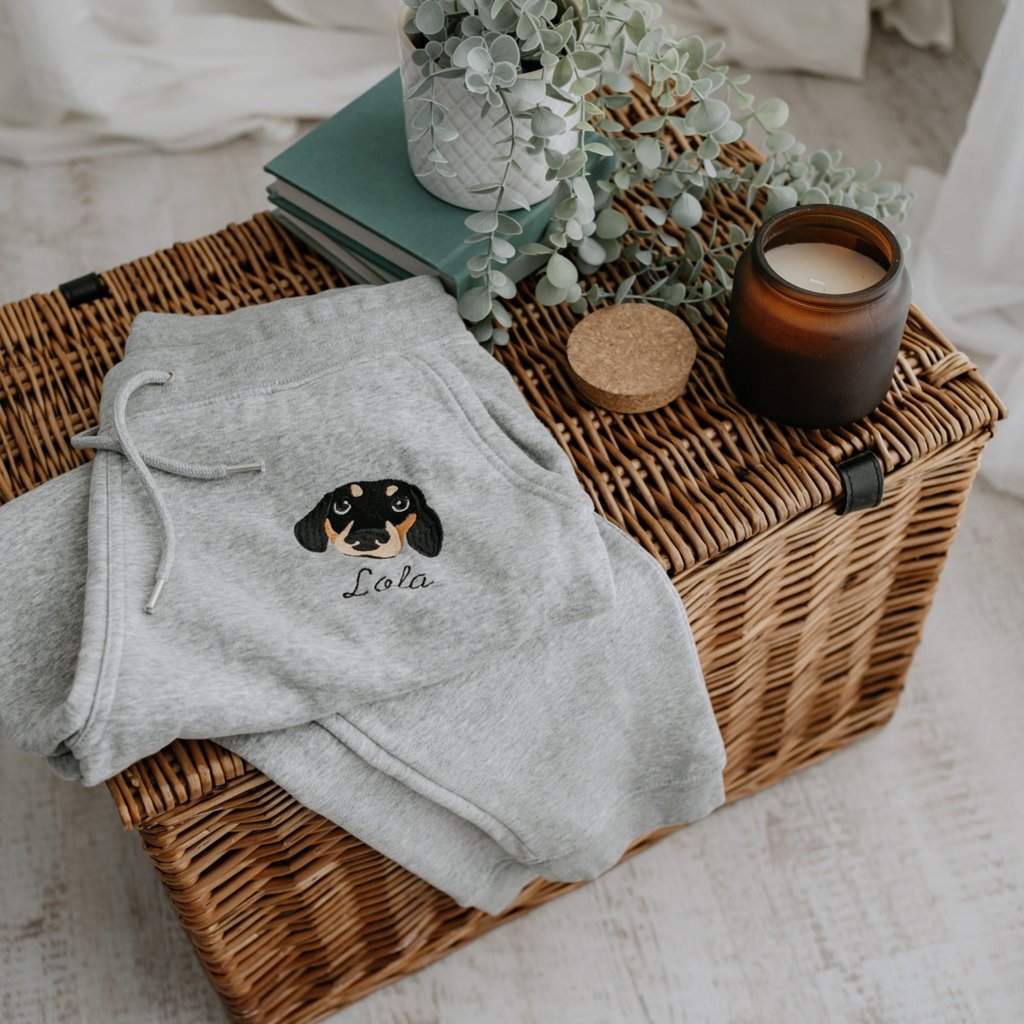 a custom embroidered organic cotton tracksuit bottoms featuring a hand-drawn pet portrait, the perfect personalised pet gift for a dog mum