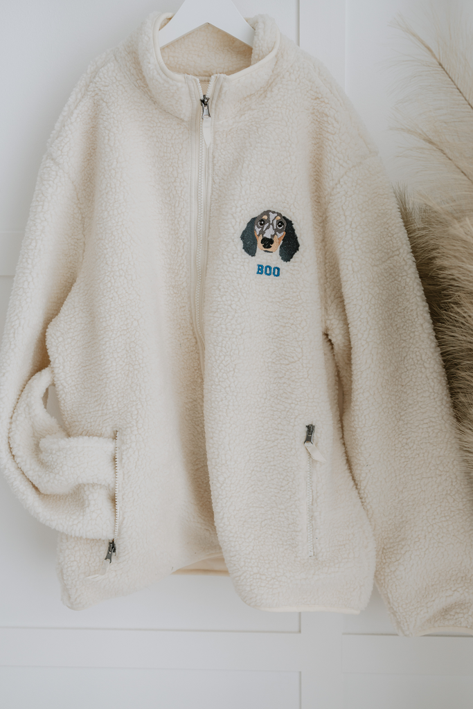 a custom embroidered dog walker sherpa jacket featuring a hand-drawn pet portrait, the perfect personalised pet gift for a dog mum