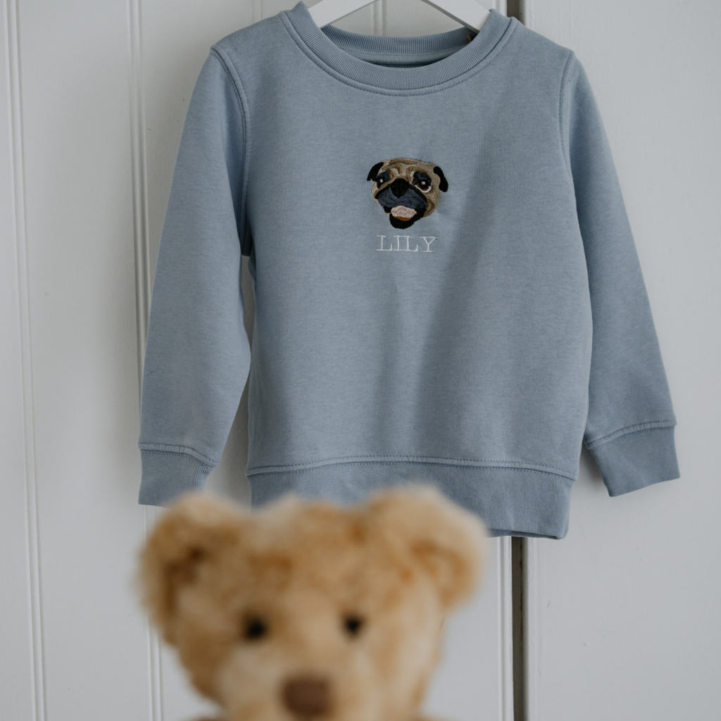 Custom embroidered sweatshirt featuring a hand-drawn pet portrait on organic cotton fabric.
